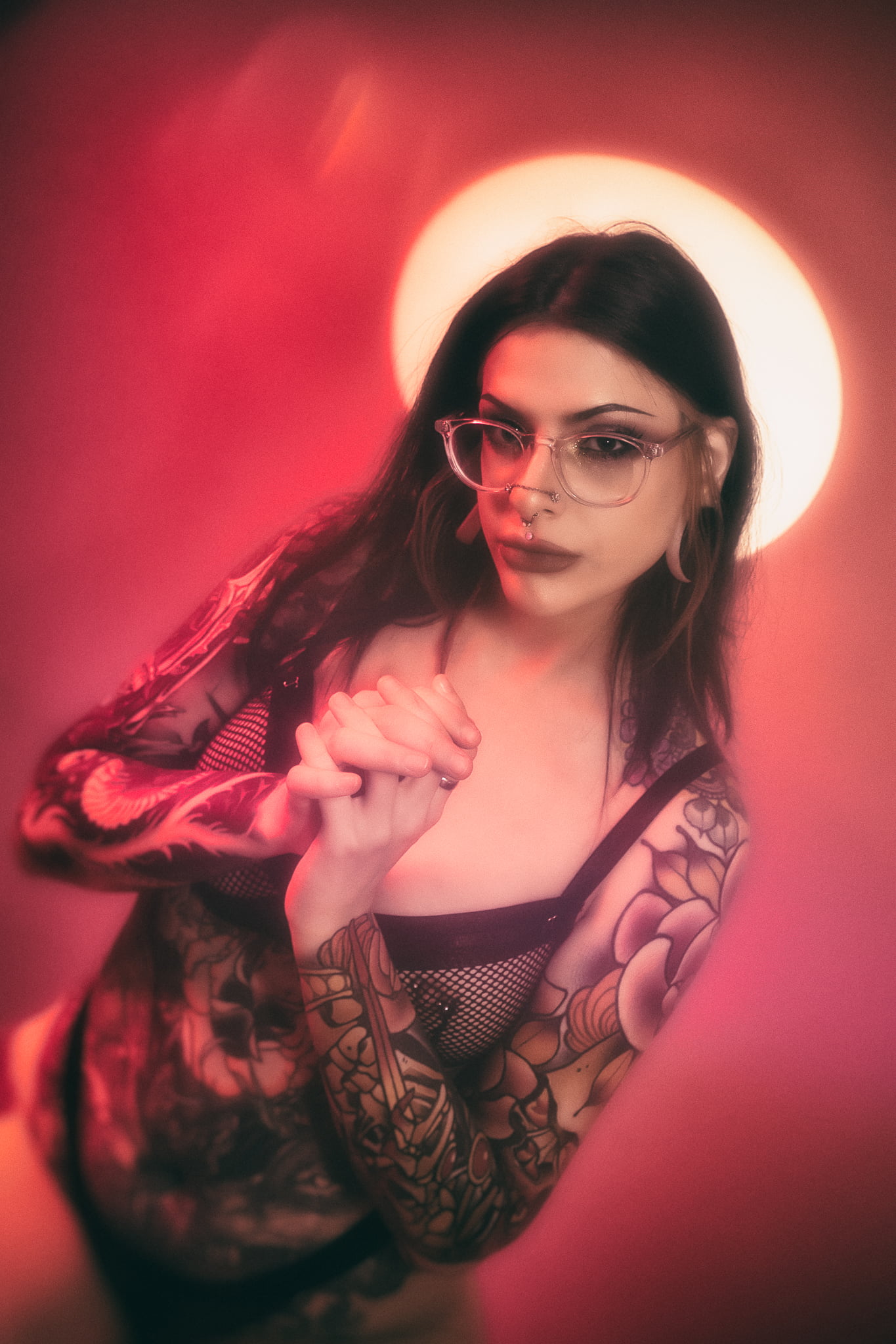 a person with tattoos and glasses