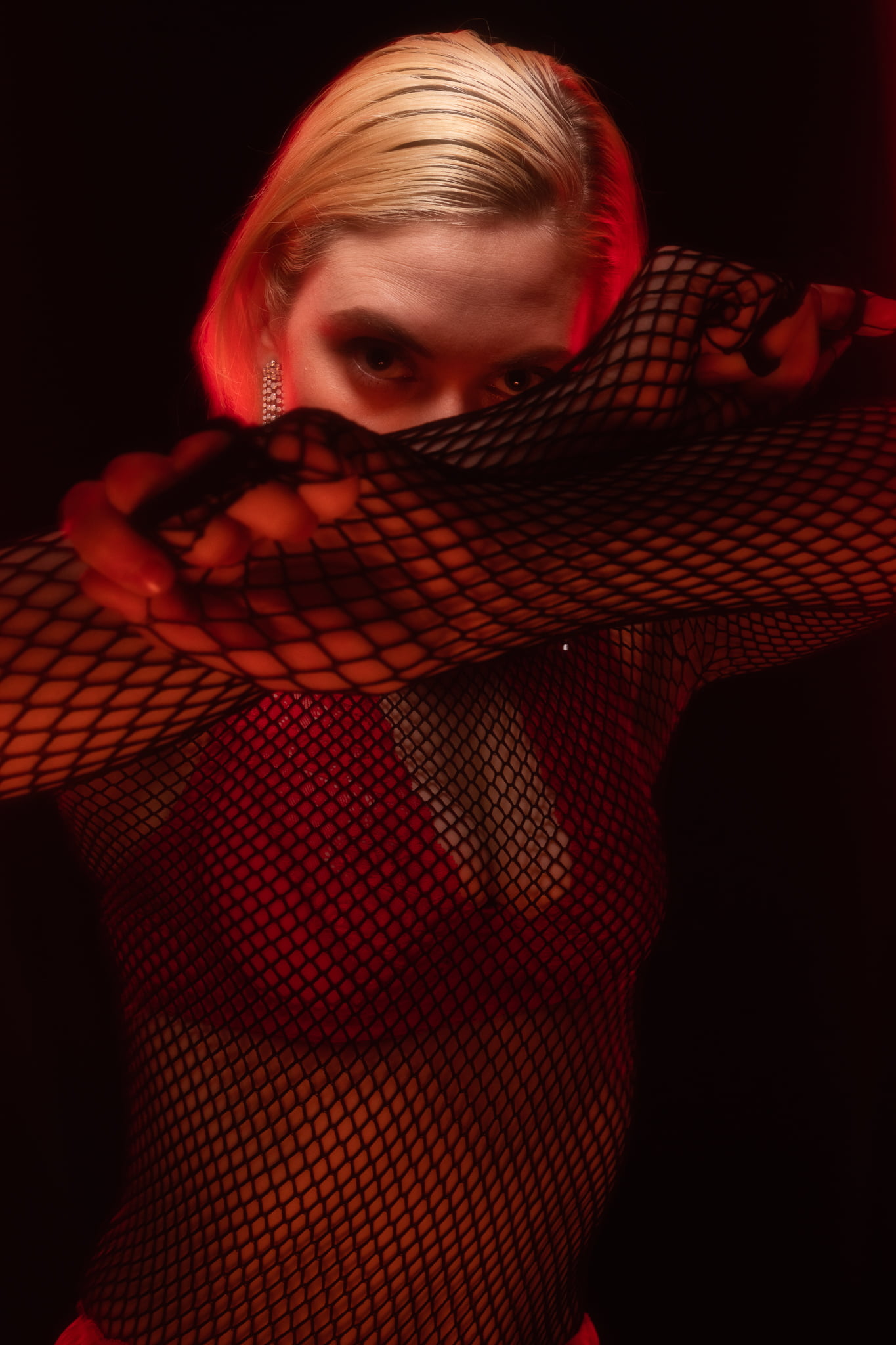 a person wearing a fishnet top and posing for a picture